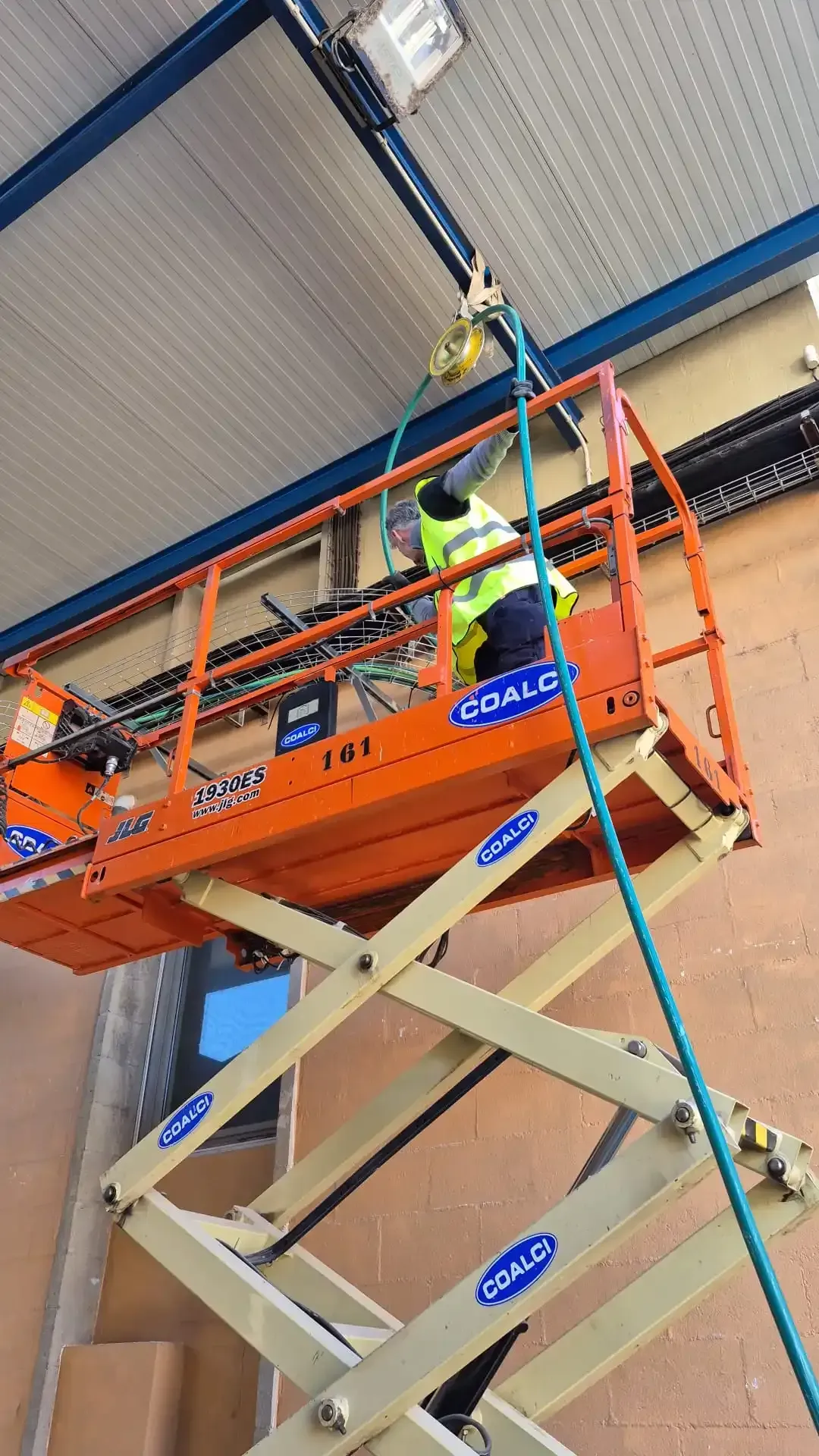 Un trabajador con un chaleco reflectante se encuentra de pie en una plataforma