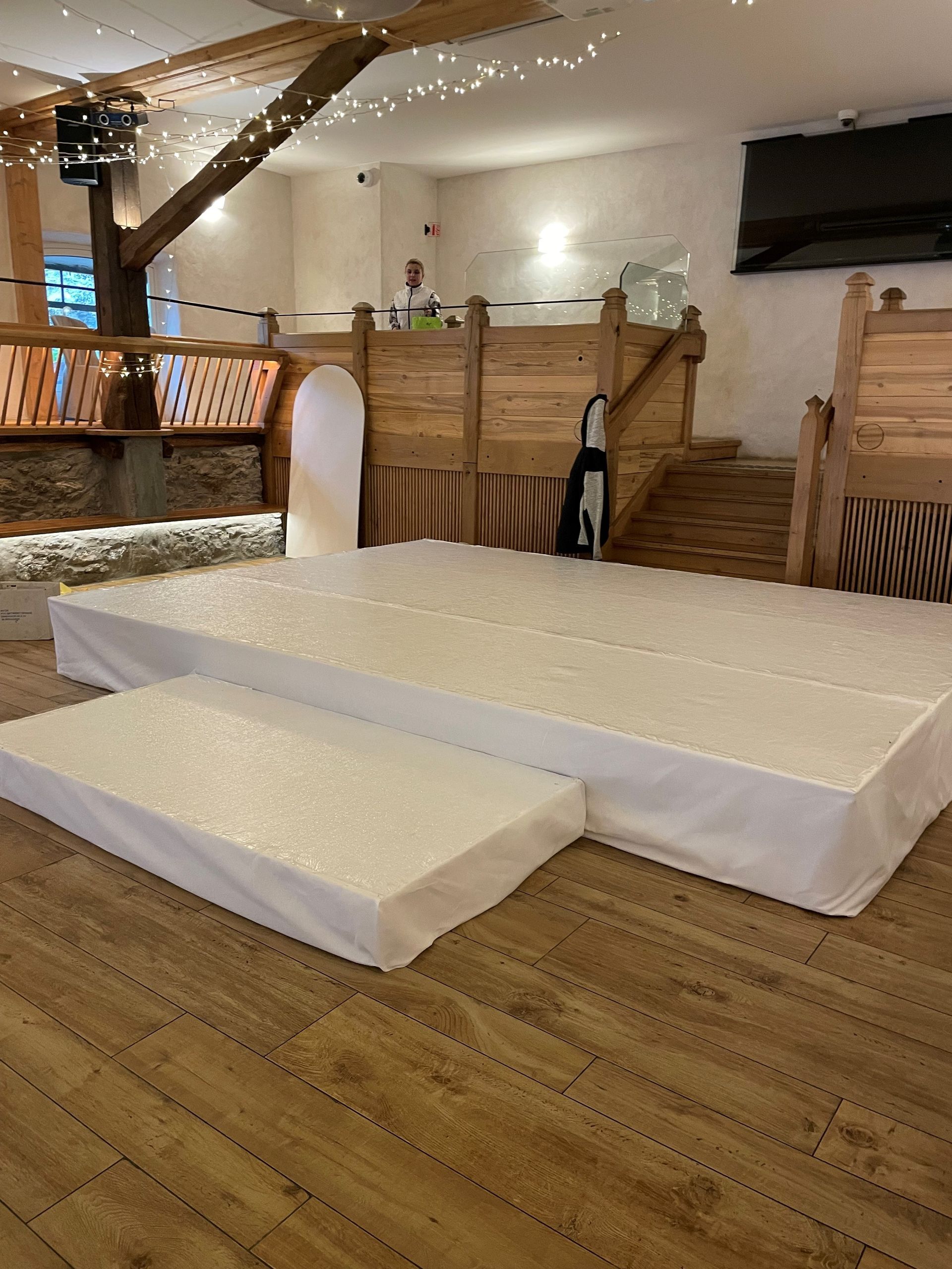 Une scène rectangulaire avec une surface noire et des pieds en métal argenté, adaptée aux spectacles.