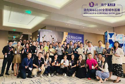 Foto de grupo de los asistentes a la conferencia en el vestíbulo de un hotel, sonriendo y sosteniendo una pancarta.