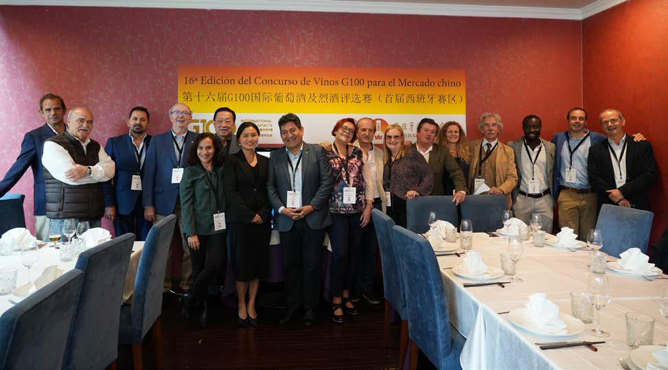 Grupo de personas posando en el comedor de un restaurante con una pancarta detrás y mesas puestas delante.