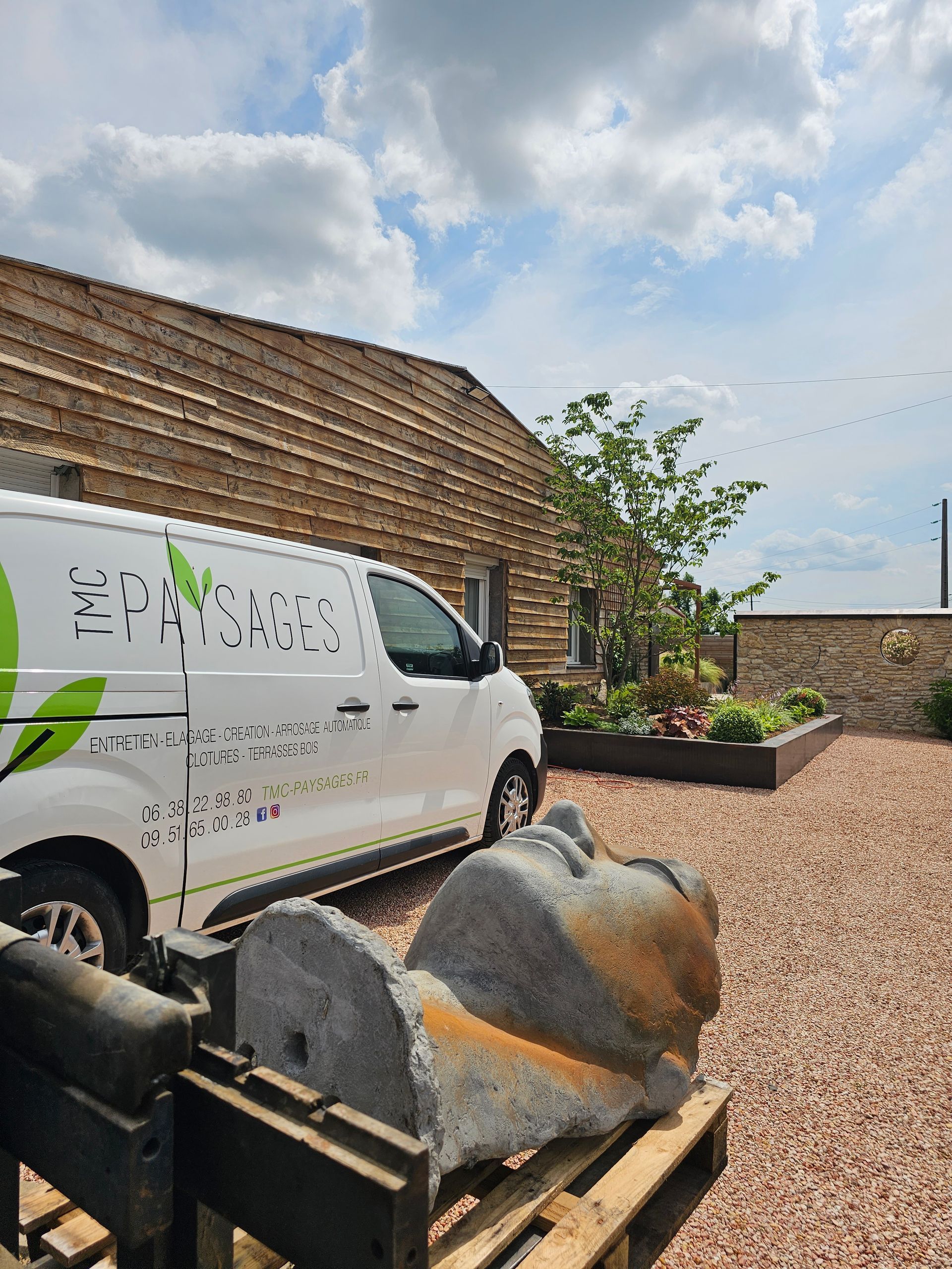 Parking aménager avec du gravier et des arbustes