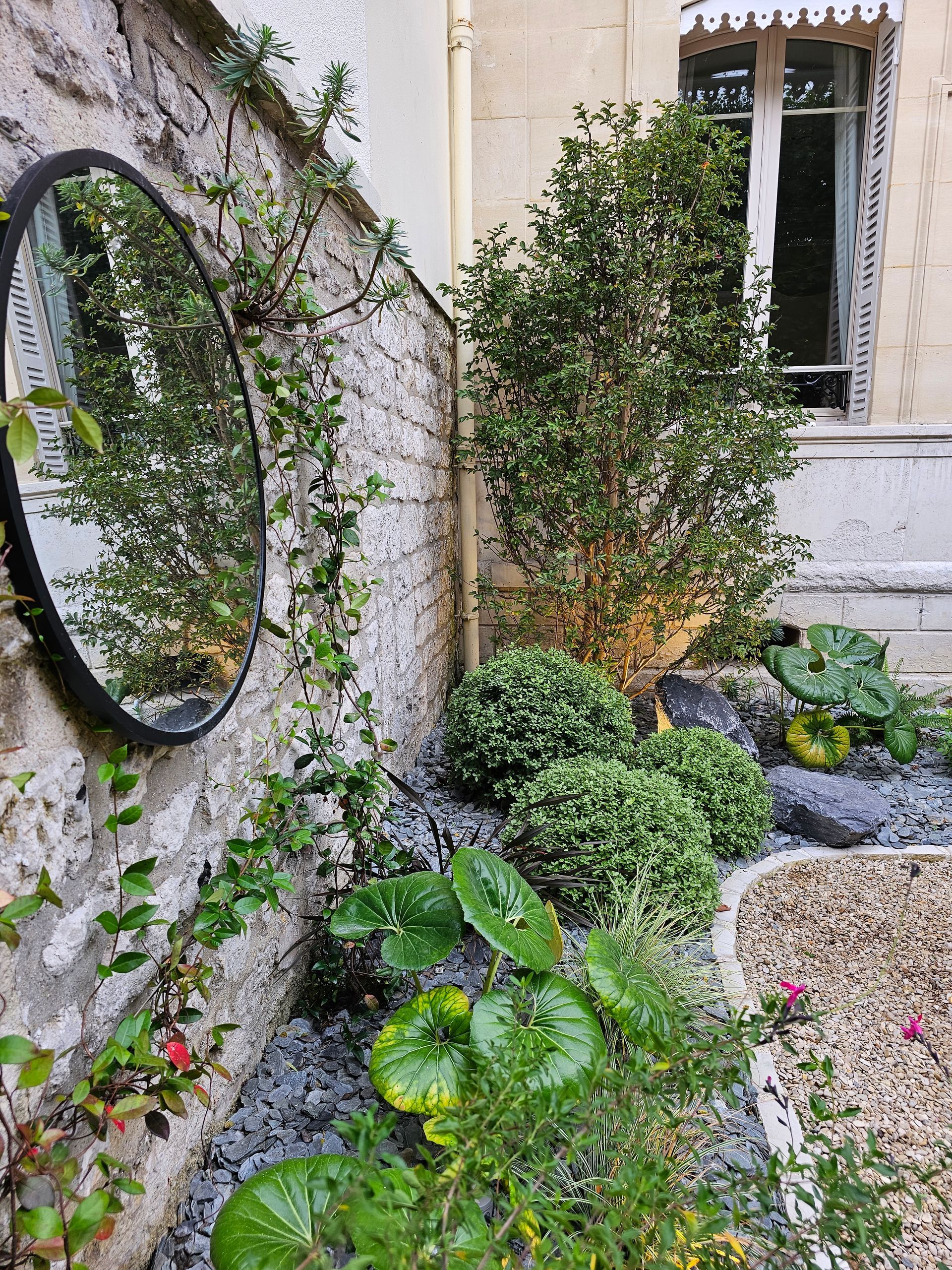 Devanture de maison aménagée avec des arbustes et buissons