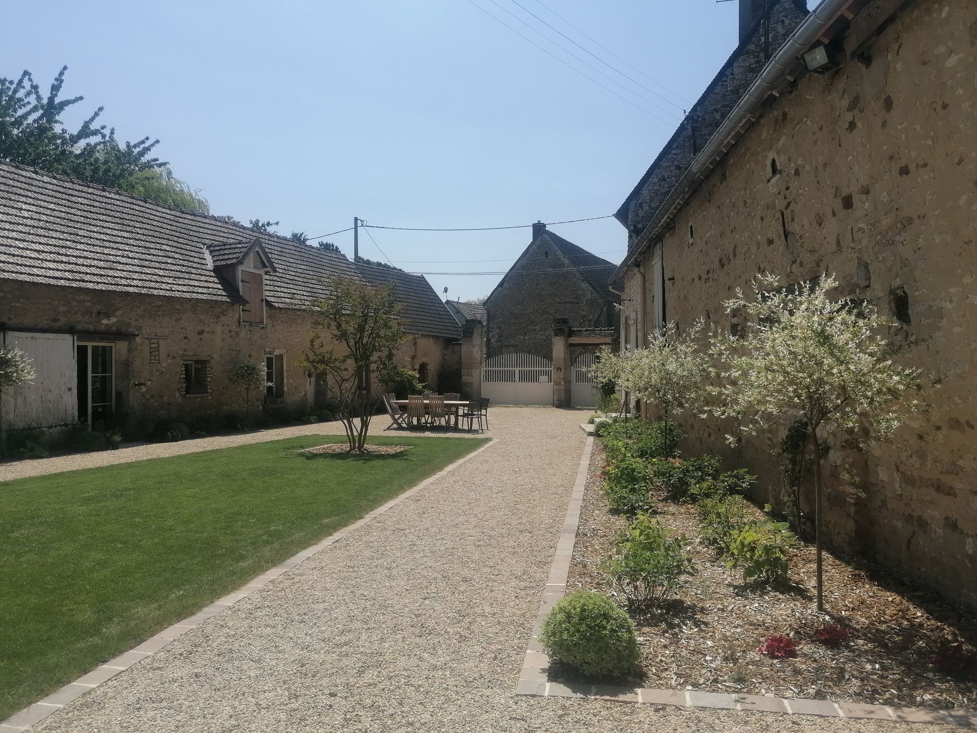Allée d'un jardin dans une cour avec par terre de fleurs