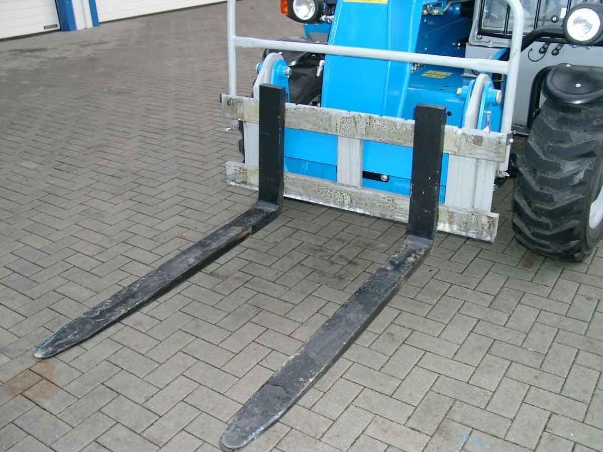 Frontlader-Gabelstapler mit langen schwarzen Gabeln auf einer befestigten Fläche