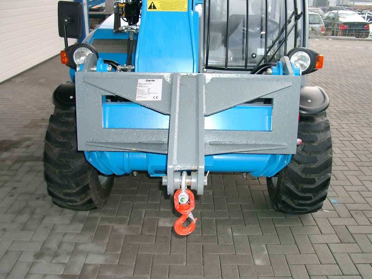 Vorderansicht eines blauen Traktors mit großen Reifen und rotem Abschlepphaken auf einer befestigten Fläche