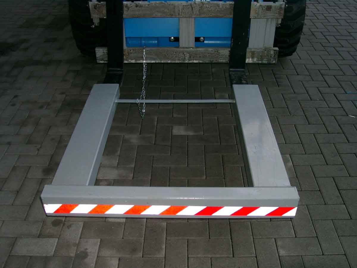 Zusammengeklappte Rollstuhlrampe am Heck eines Fahrzeugs mit rot-weißen reflektierenden Streifen am Rand.