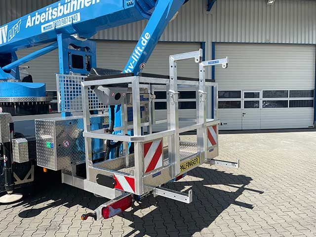 Blaue Hubarbeitsbühne mit angebauter Arbeitsplattform vor einem Industriegebäude.