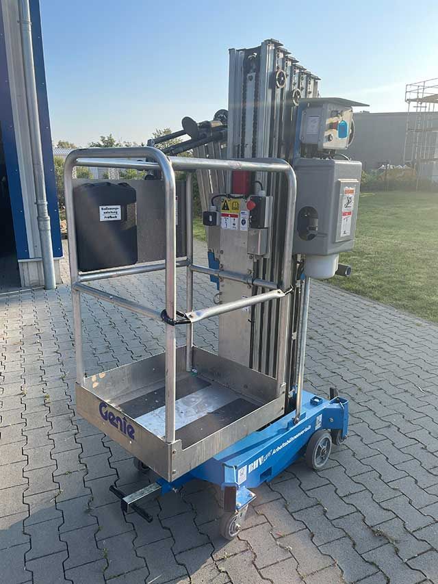 Blaue mobile Wartungshebebühne mit Metallplattform und Bedienelementen im Freien auf befestigten Flächen.