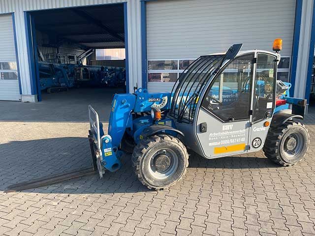 Ein blauer Teleskopstapler steht vor einer Industriehalle mit offenen Toren.