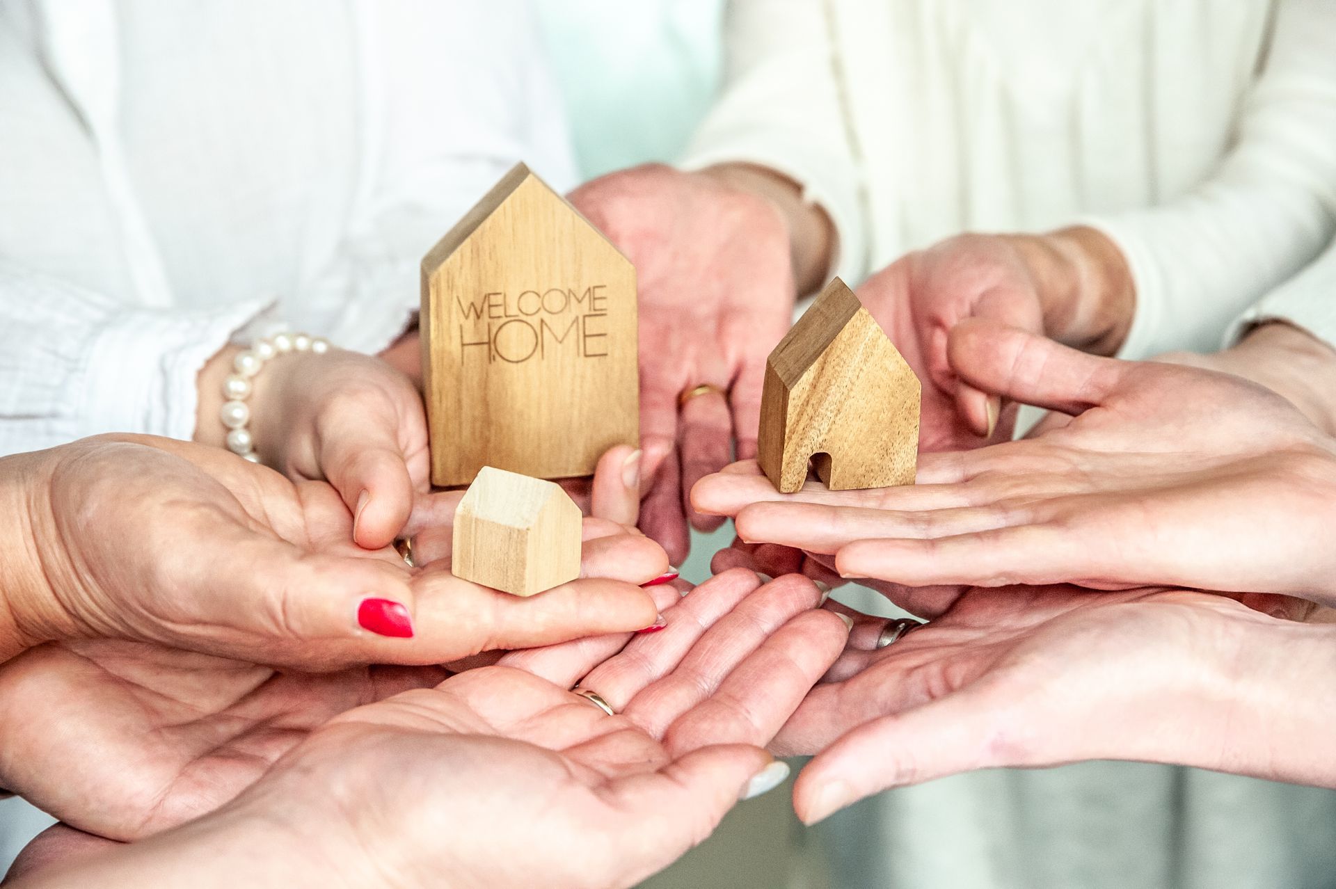 eine Person hält einen Schlüssel mit einem kleinen Holzhaus darauf eine Person hält einen Schlüssel mit einem kleinen Holzhaus darauf