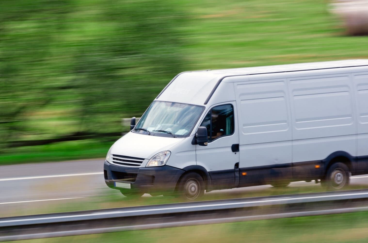 Una camioneta blanca circula por una autopista.