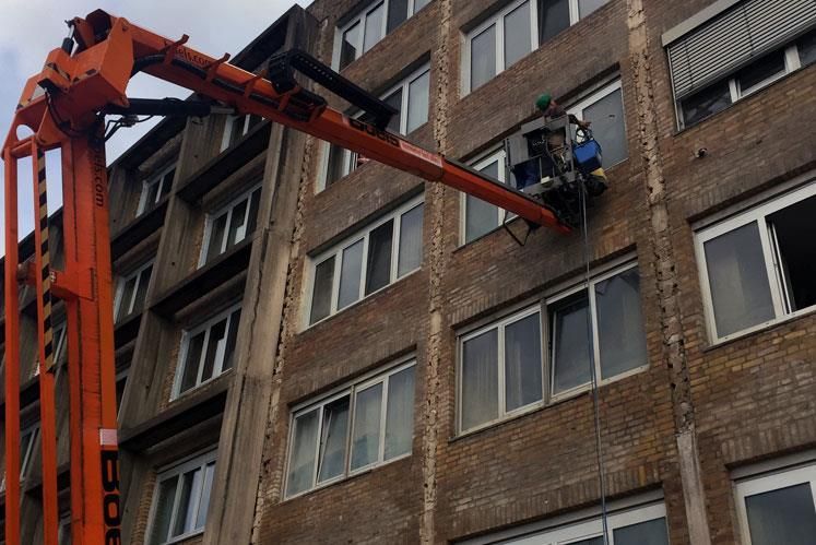 Ein großes Backsteingebäude mit einem Kran davor, auf dem „Boc“ steht