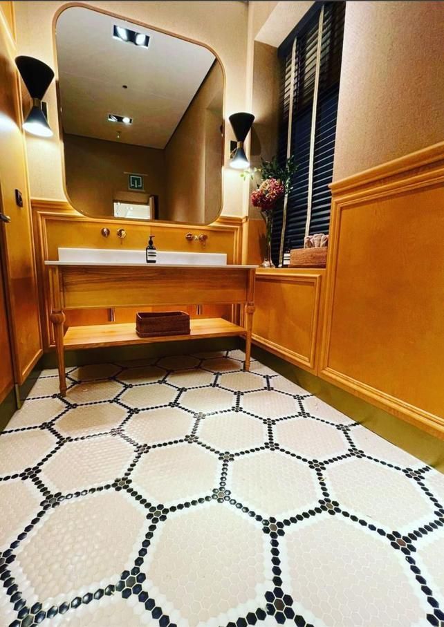 Un baño con dos lavabos y suelo de mosaico.