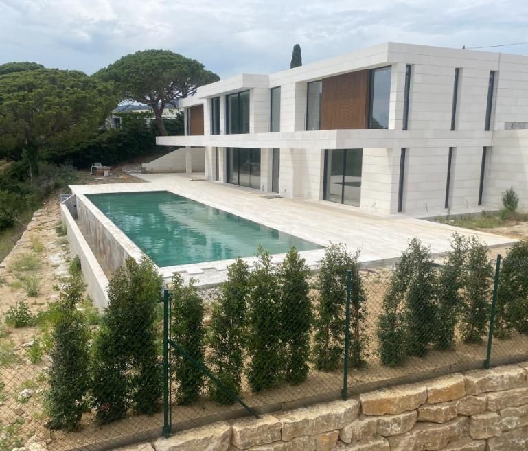 Casa moderna blanca con piscina rectangular y paisajismo.
