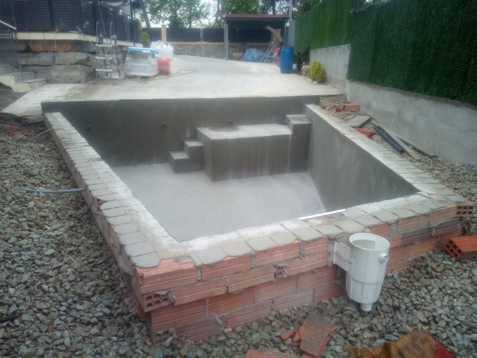 Piscina en construcción con marco de ladrillo y escalones.