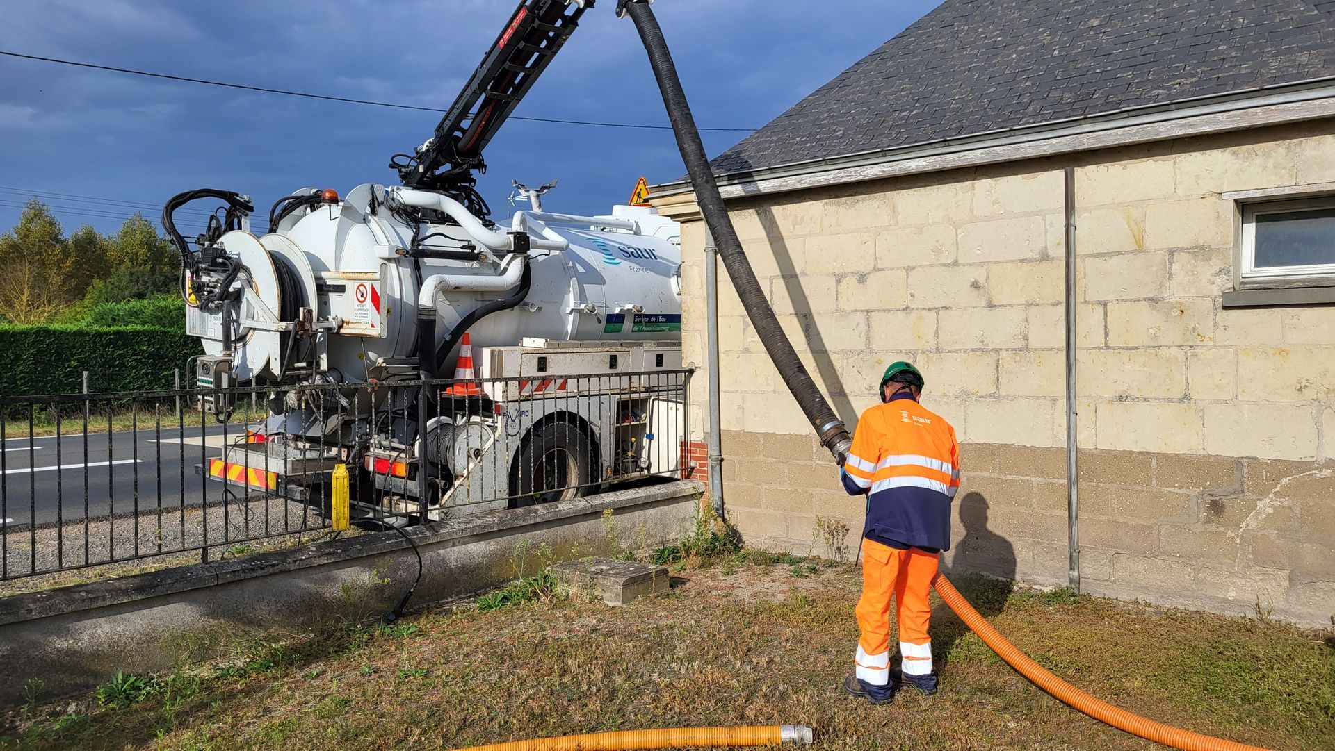 Une hydrocureuse à côté d'une maison.