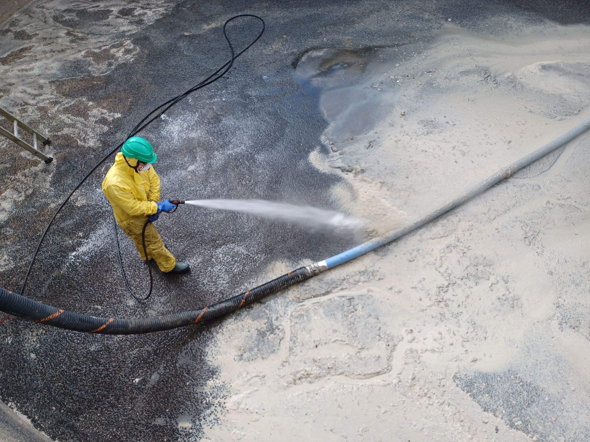 Un technicien en jaune avec un jet à haute pression.
