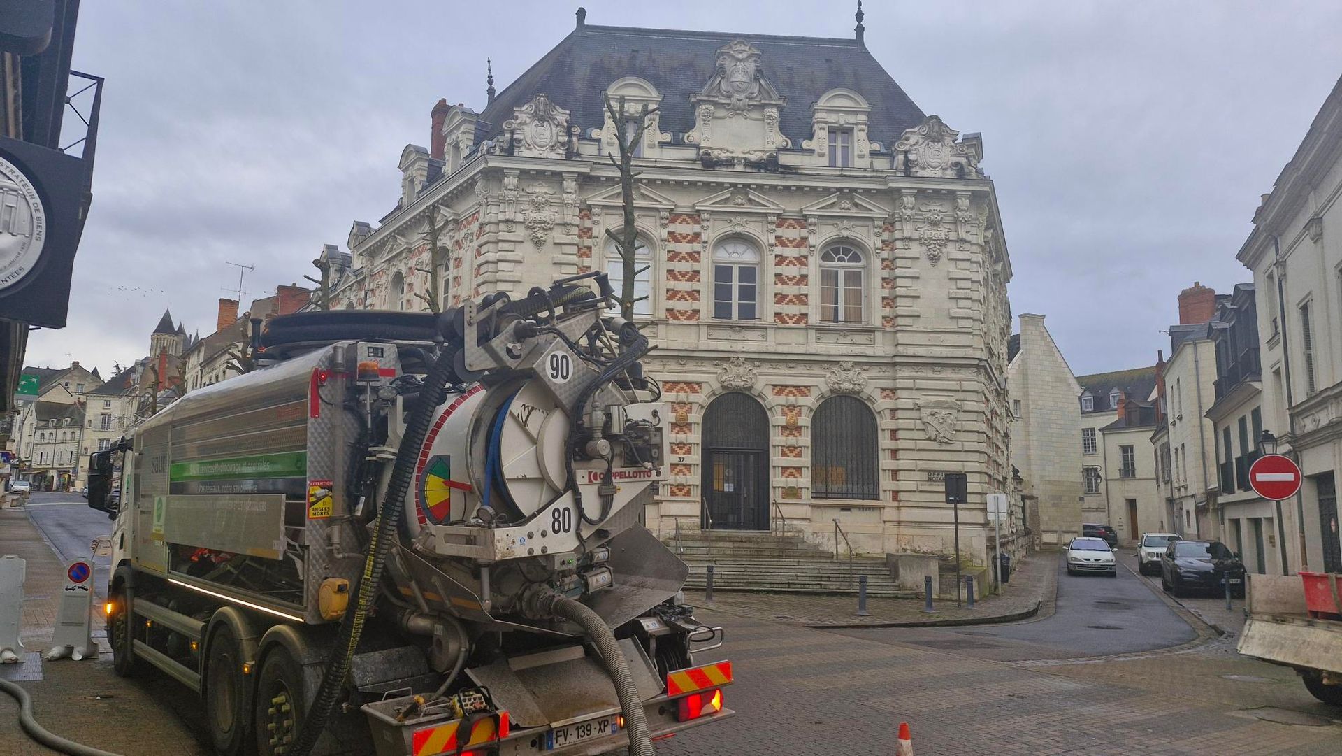 Camion d'hydrocurage devant un bâtiment.