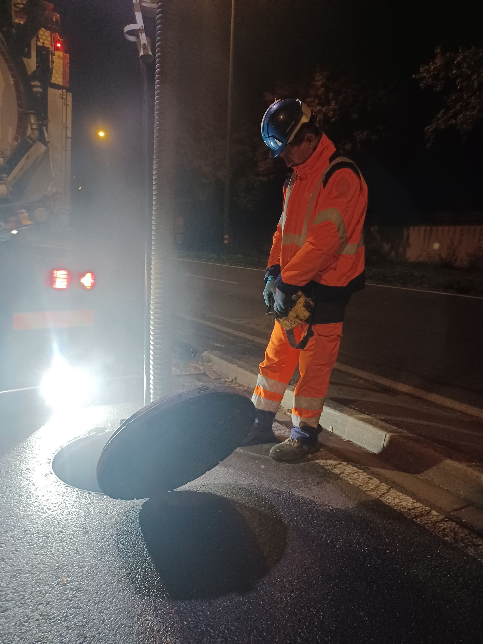 Un technicien envoie un jet à haute pression dans une canalisation.