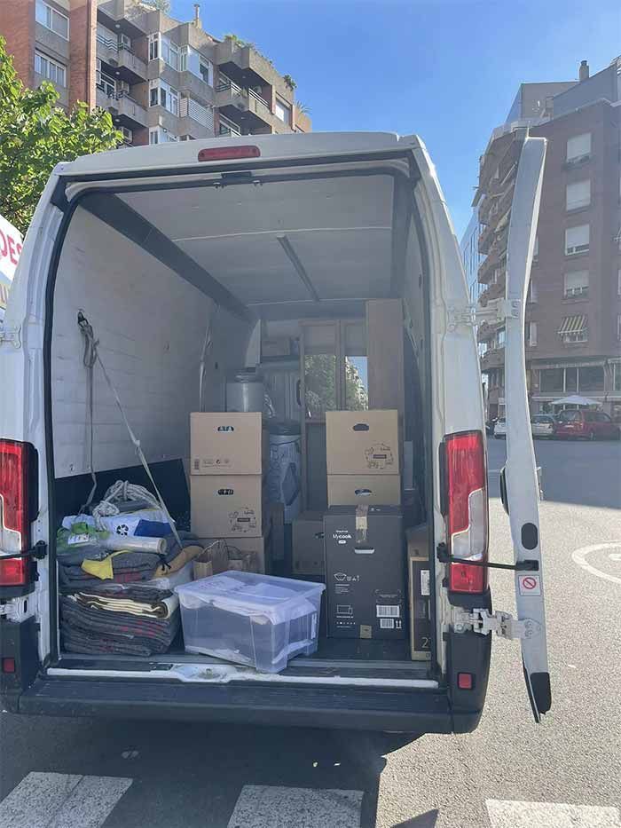 La parte trasera de una camioneta blanca está llena de cajas.