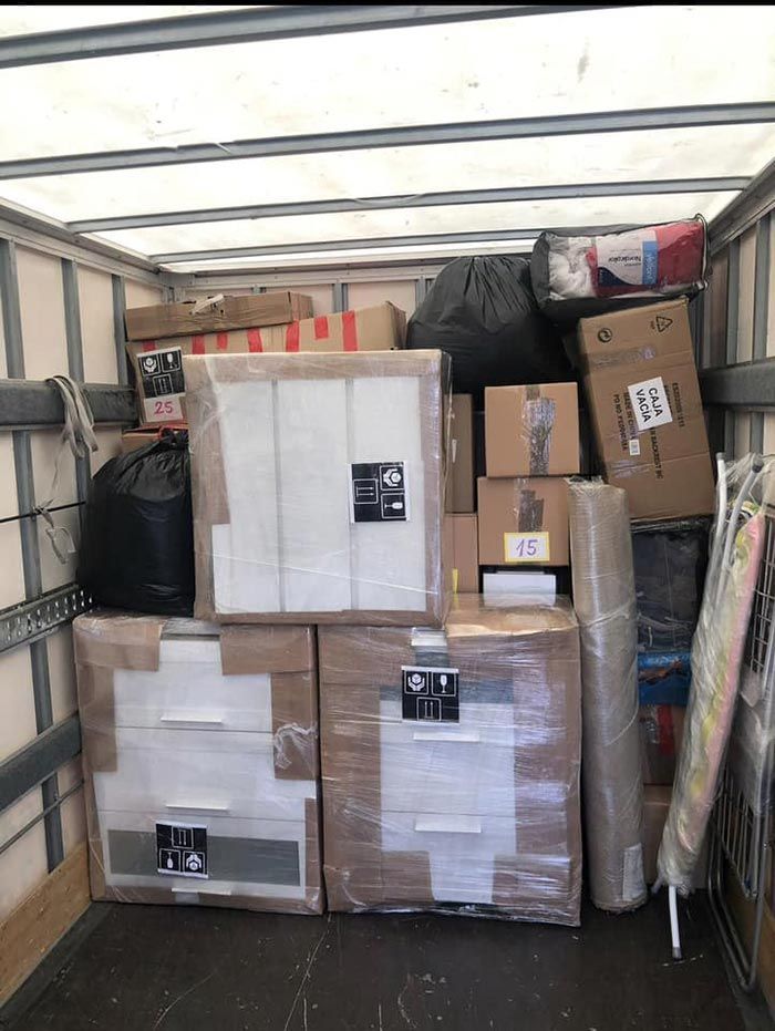 Un camión lleno de cajas y un colchón.