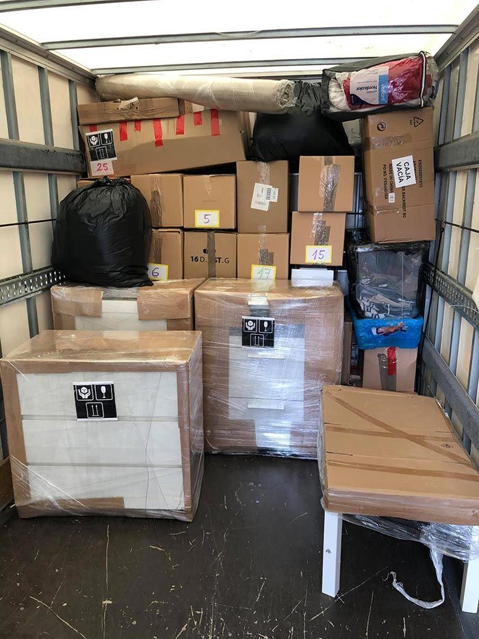 El interior de un camión de mudanzas lleno de cajas y una mesa.