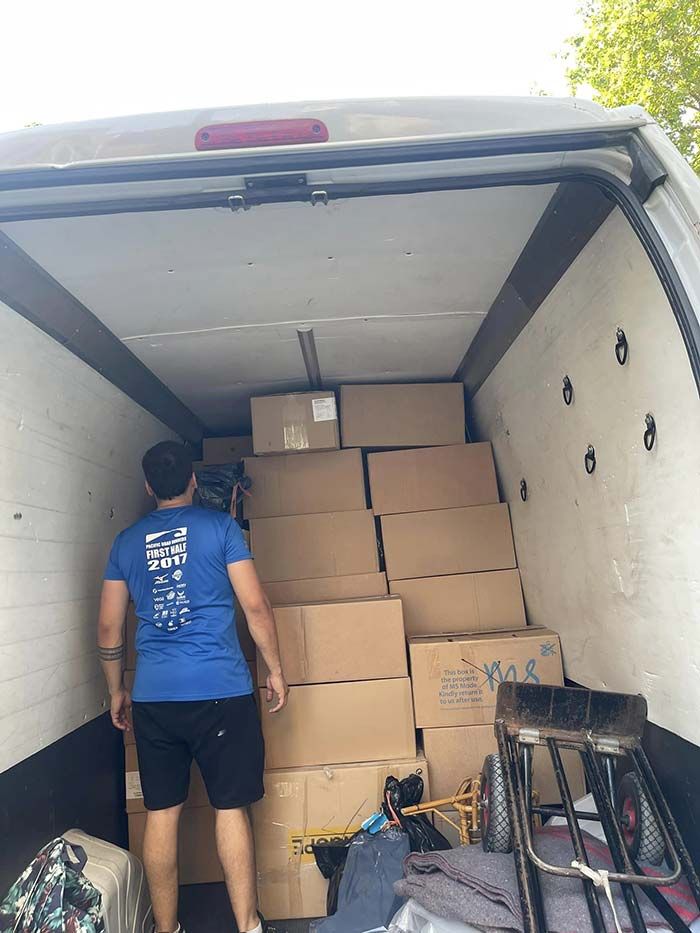 Un hombre está cargando cajas en una camioneta.