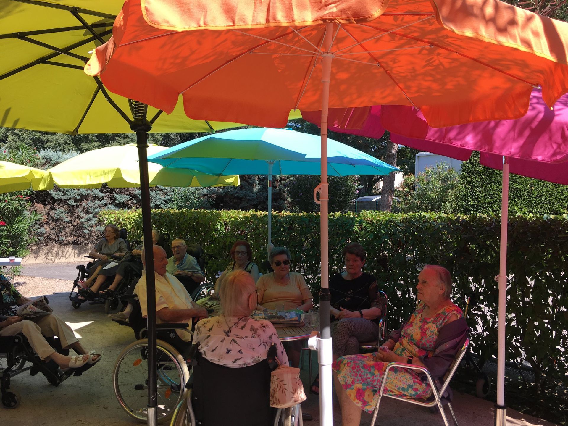Discussions entre résidents sous des parasols colorés