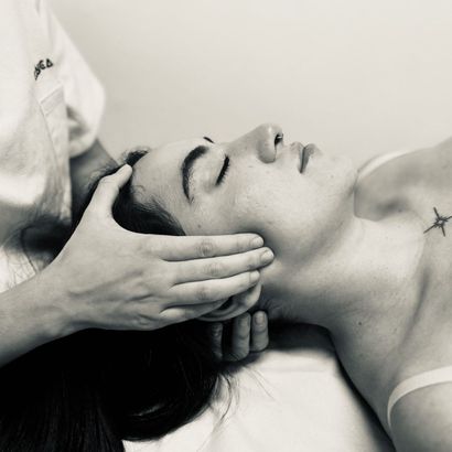 Una fotografía en blanco y negro de una mujer recibiendo un masaje.