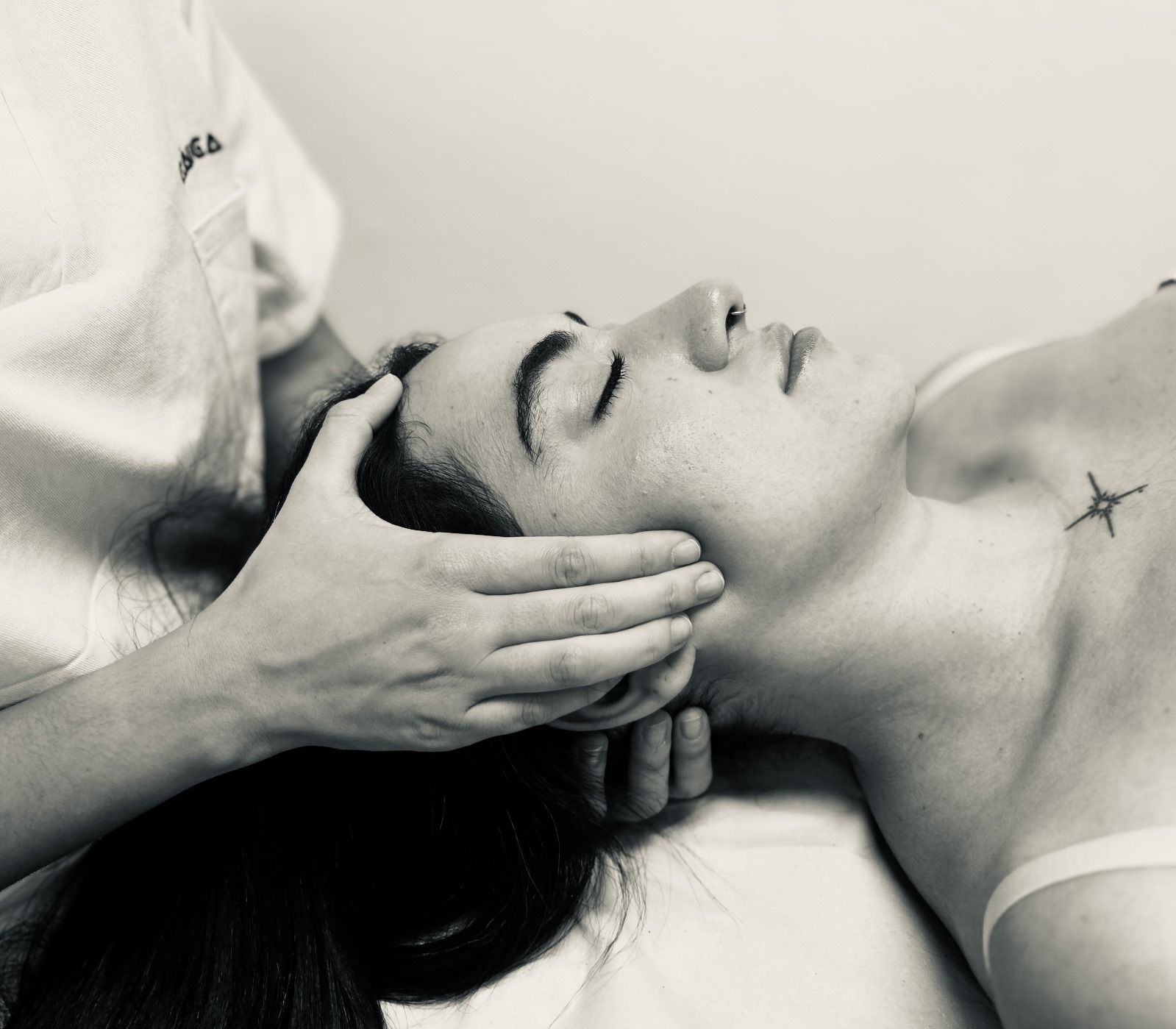 Una fotografía en blanco y negro de una mujer recibiendo un masaje en la cabeza.