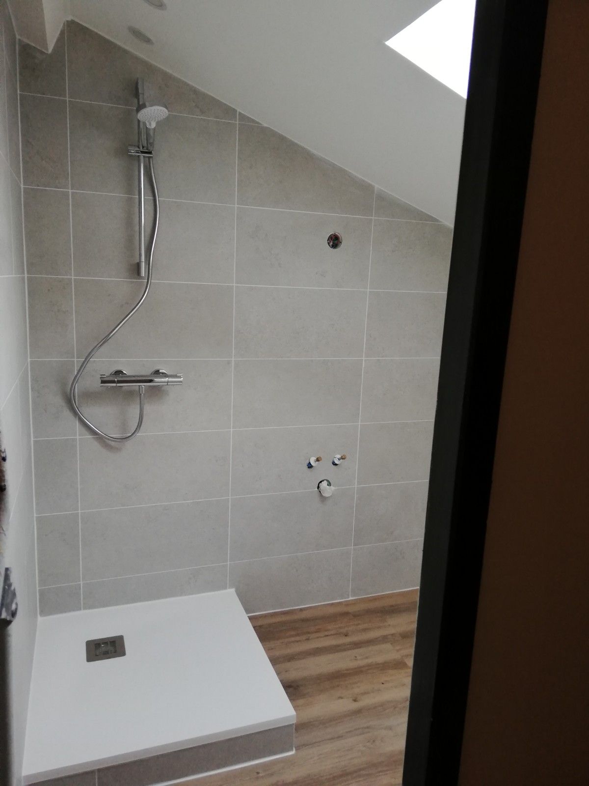 Pose d'une grande douche avec des carreaux beiges