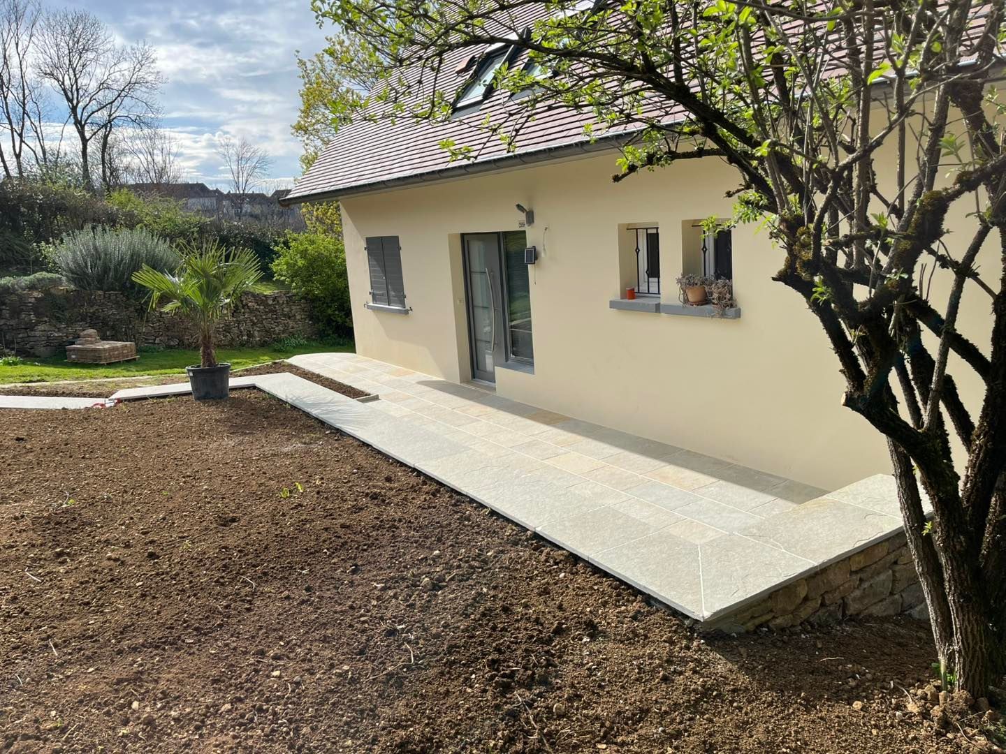 Façade d’une maison avec une terrasse dallée