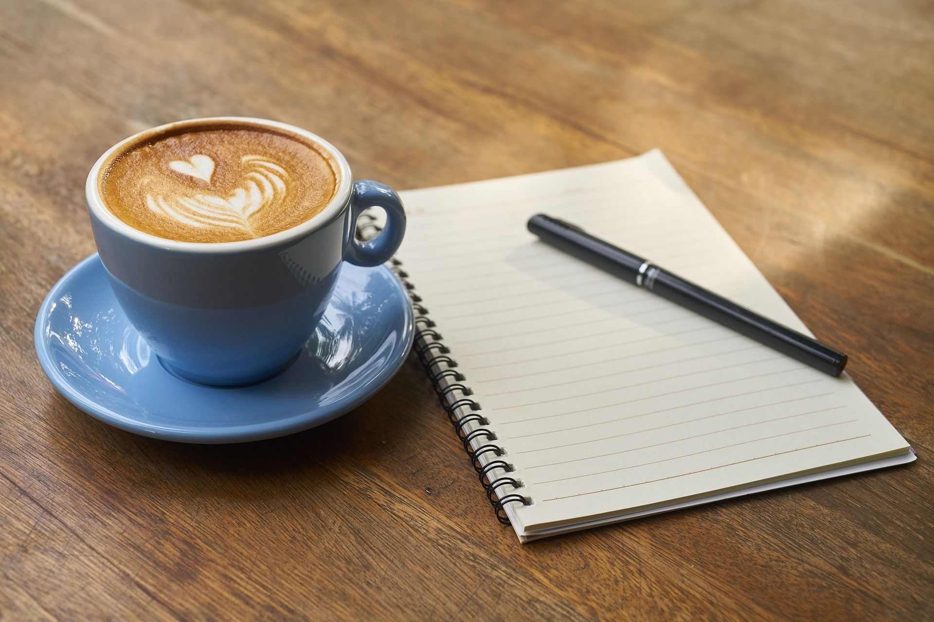 Schreibblock mit Stift und Kaffeetasse