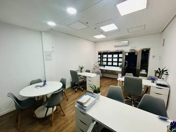 Dos personas se dan la mano sobre un contrato sobre una mesa; un bolígrafo cerca.