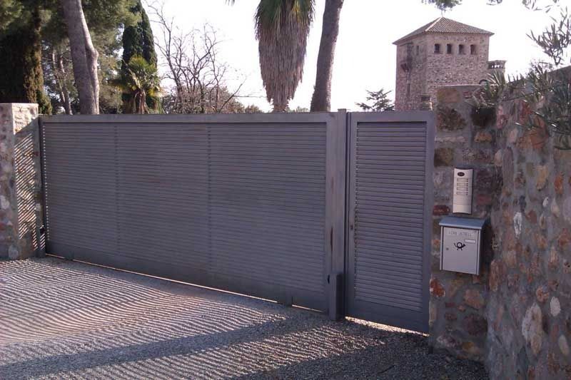 Una puerta corrediza con un buzón delante.