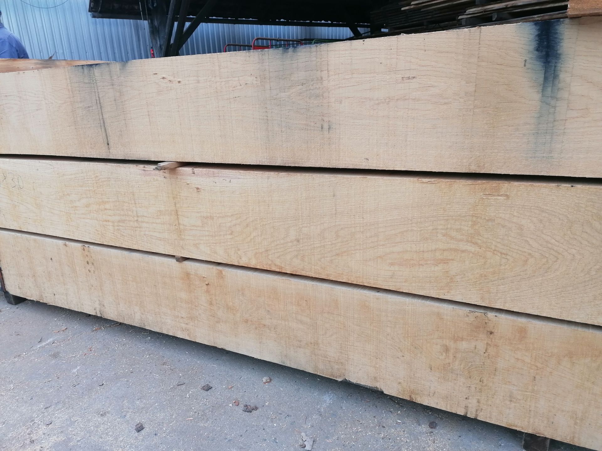 Stapel heller Holzbretter mit sichtbarer Maserung, horizontal gestapelt.