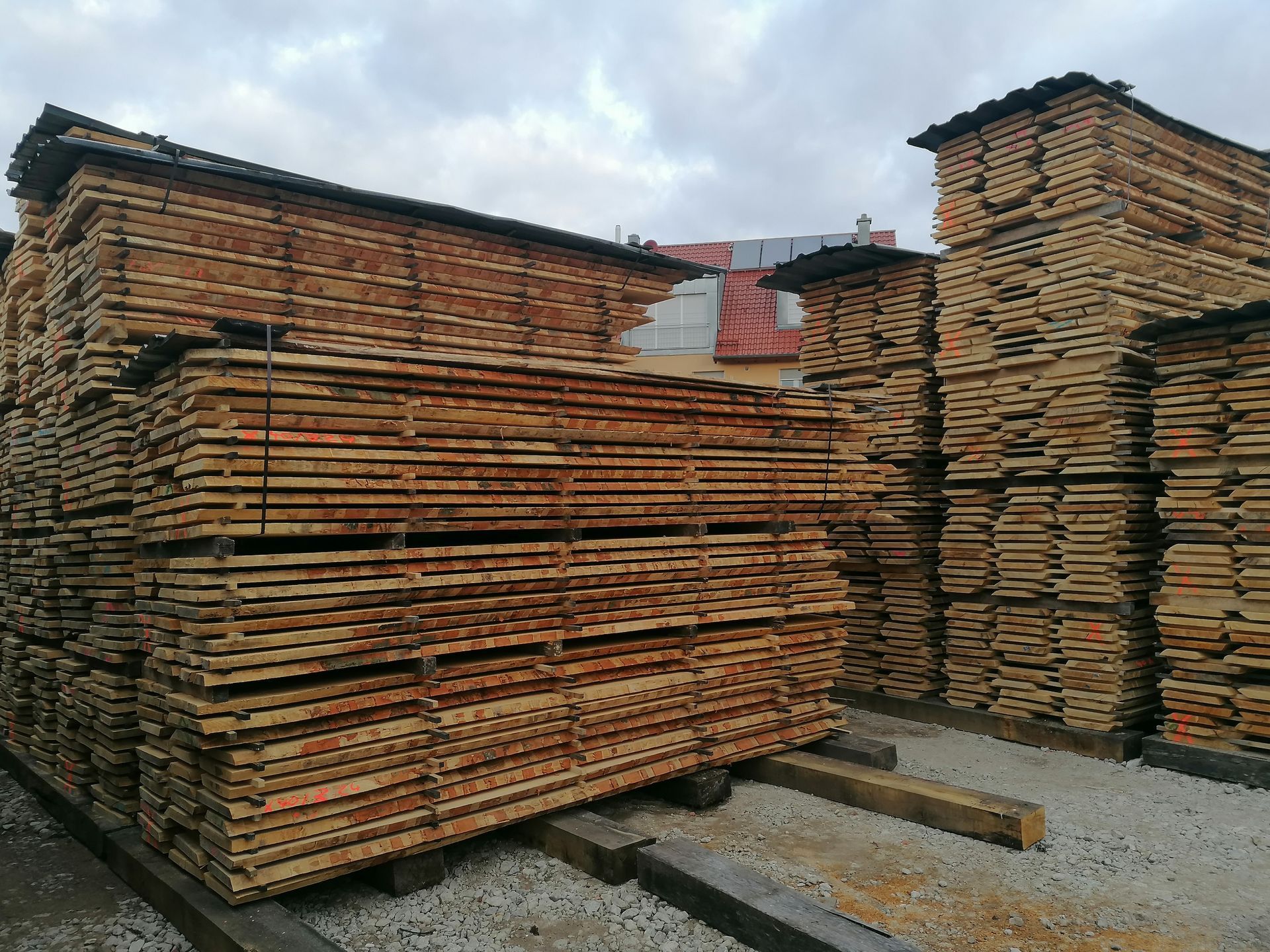 Holzstapel trocknen in einem Holzlager, hoch aufgestapelte Holzbretter im Freien.