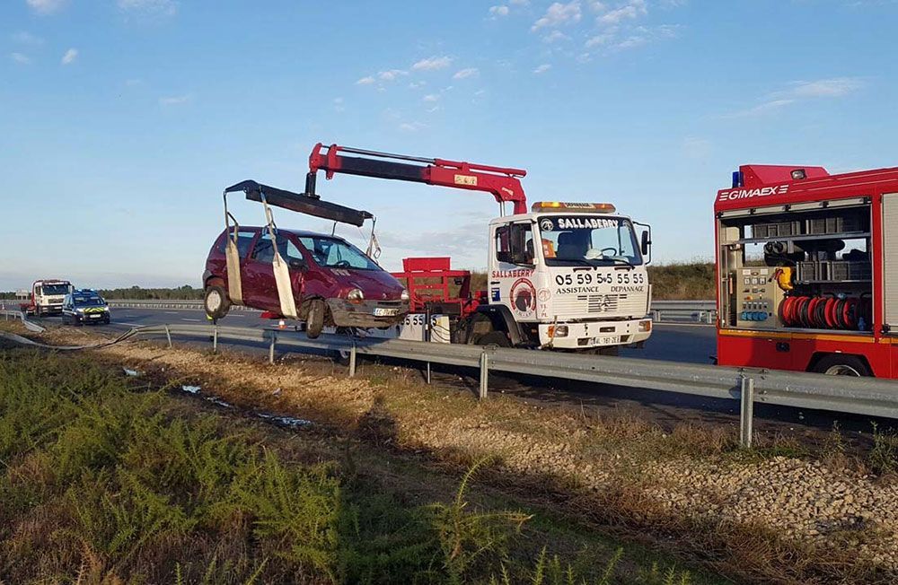 Une twingo soulevée par une dépanneuse après une sortie de route