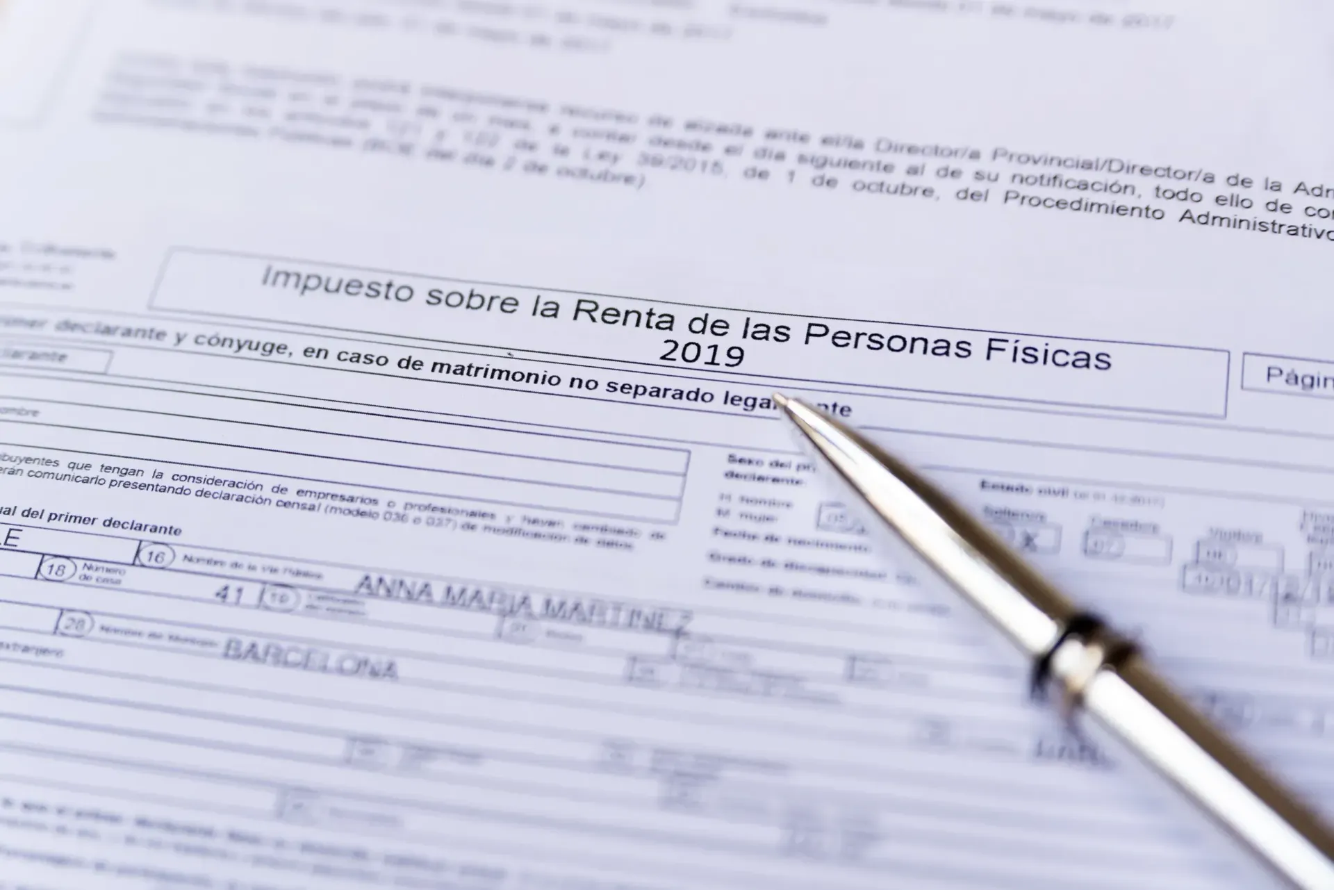 Una persona con un blazer beige sostiene una taza de café mientras habla por teléfono inteligente