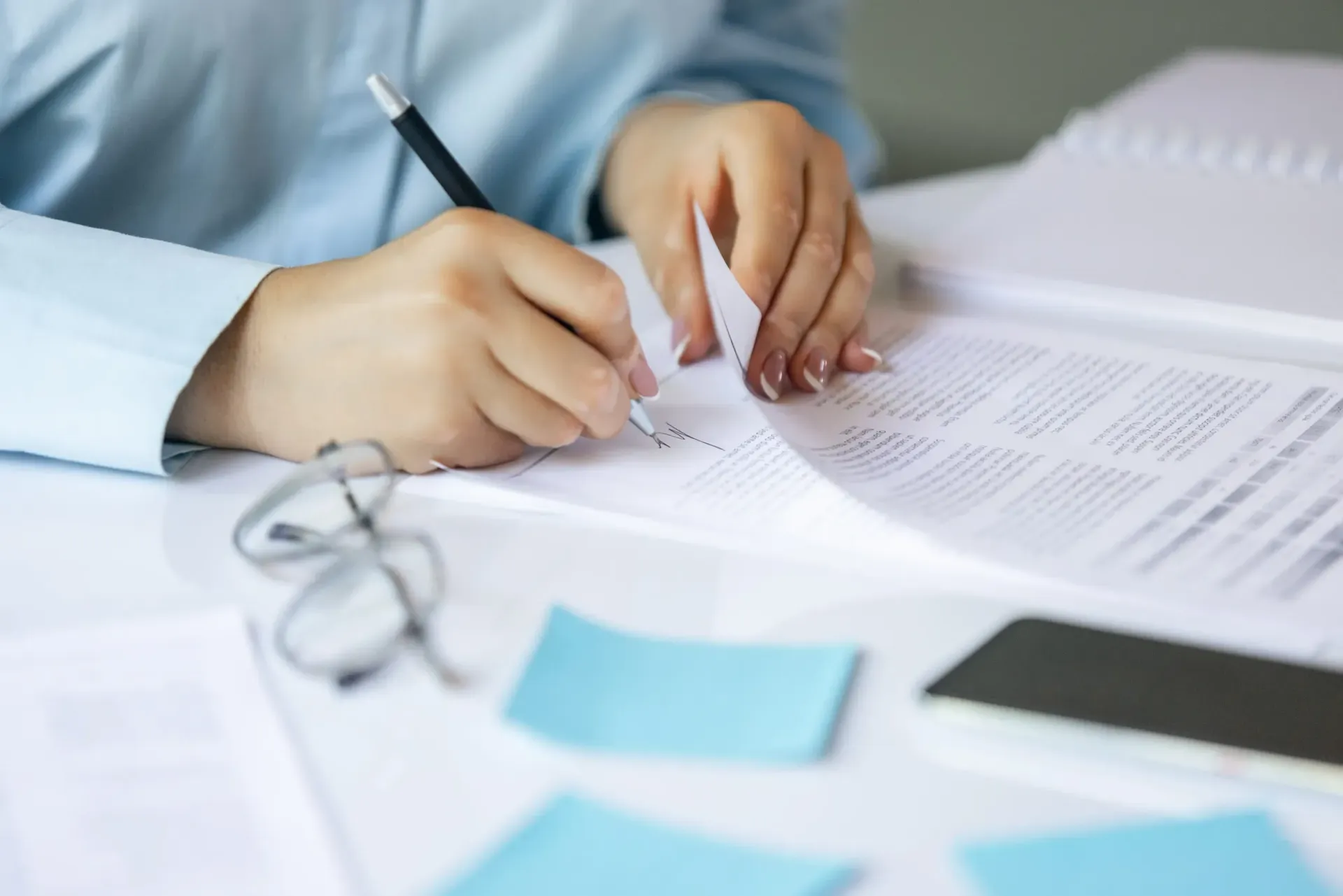 Vista desde arriba de seis personas alrededor de una mesa de madera con ordenadores portátiles y libretas