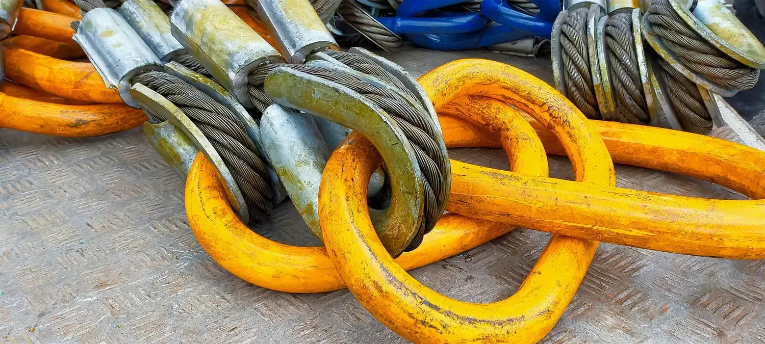 Eine Nahaufnahme eines Bündels gelber Seile und Haken auf einer Betonoberfläche.