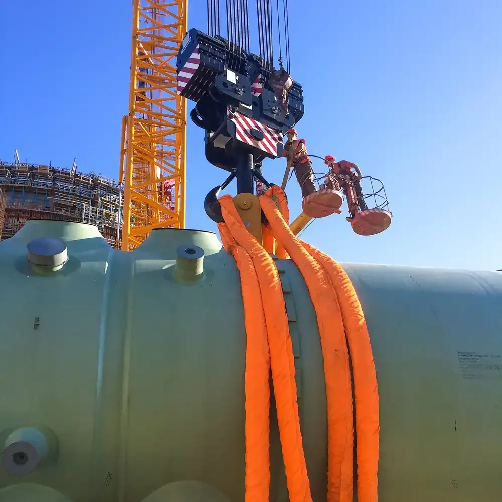 Ein großes grünes Rohr wird von einem Kran angehoben