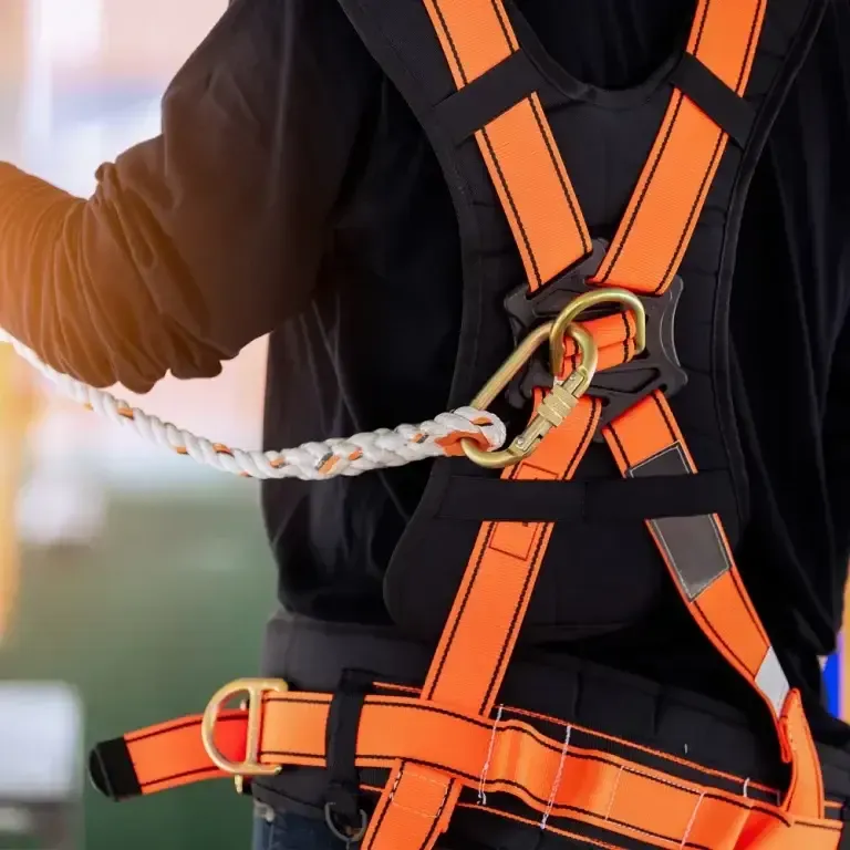 Eine Person, die einen Sicherheitsgurt trägt, an dem ein Seil befestigt ist