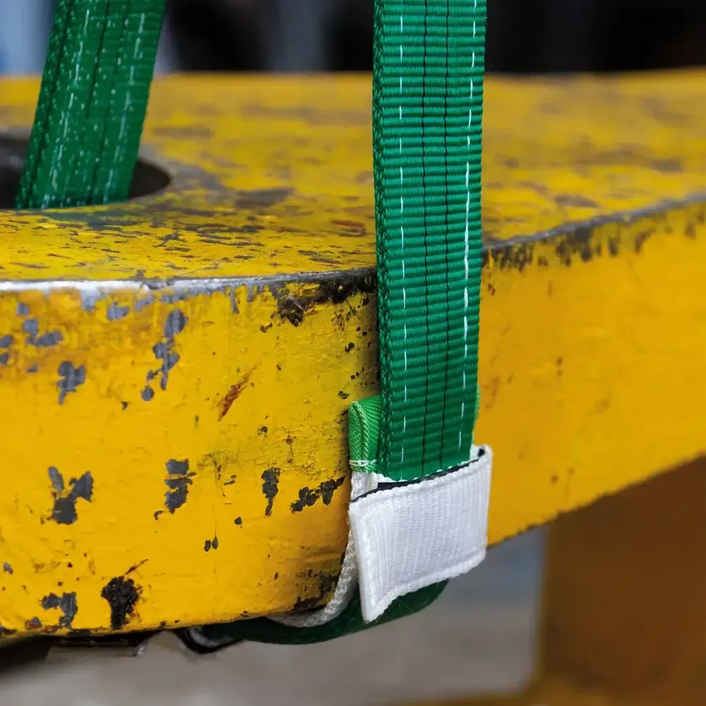 Eine grüne Schlinge ist an einer gelben Fläche befestigt.