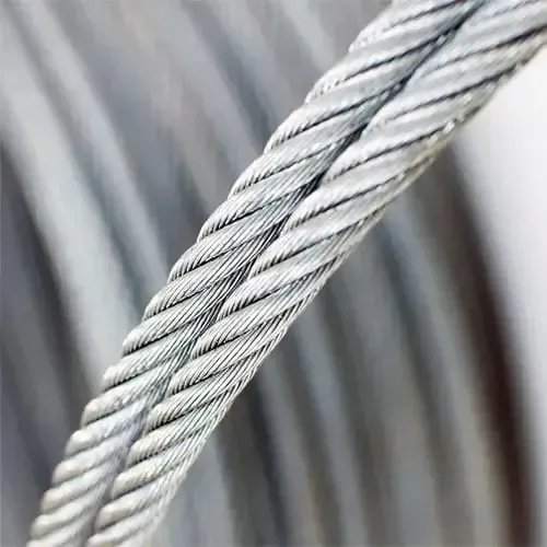 Eine Nahaufnahme eines Edelstahldrahtseils auf einer weißen Oberfläche.