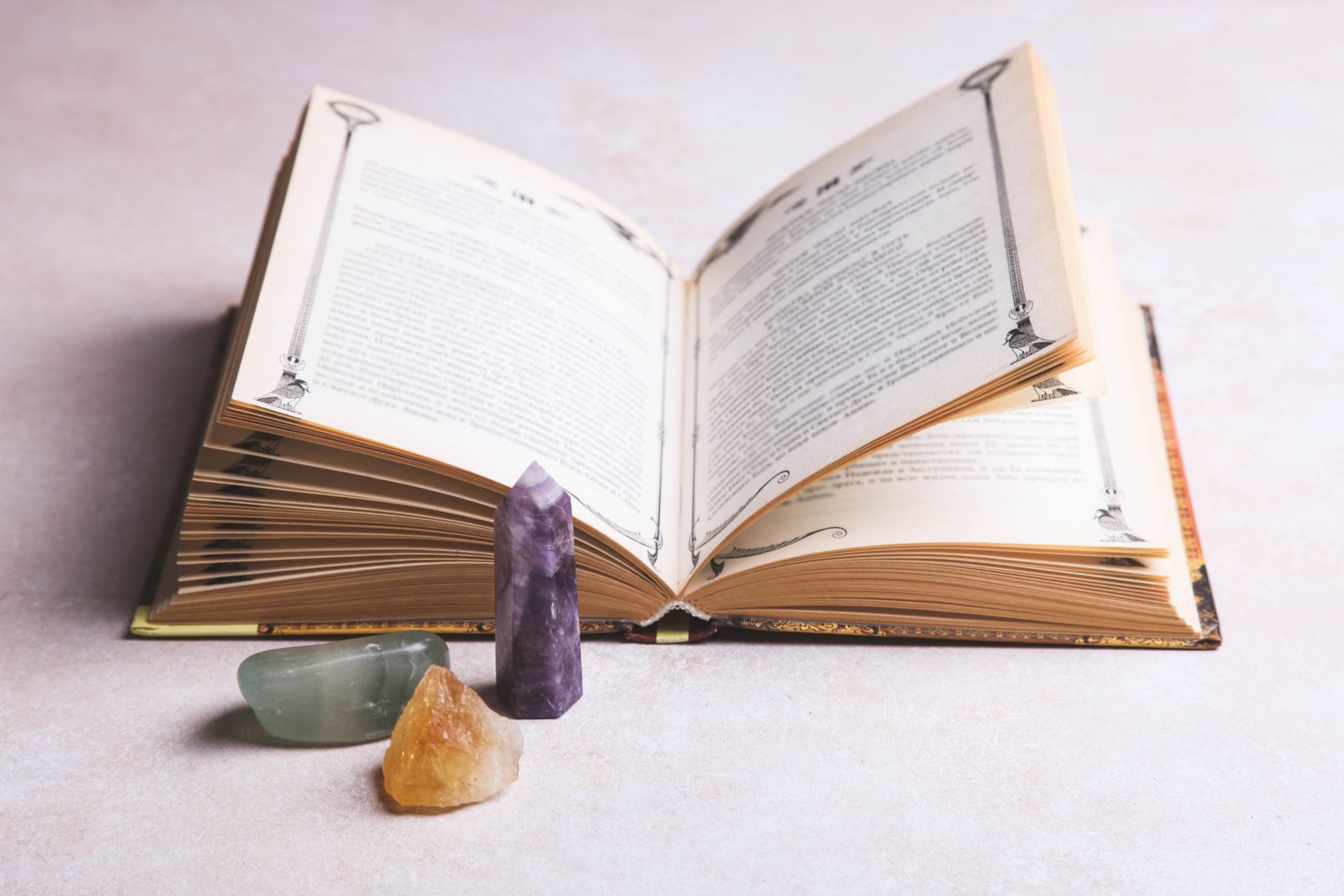 Un libro abierto sobre una mesa de madera con velas y un pájaro saliendo de él.