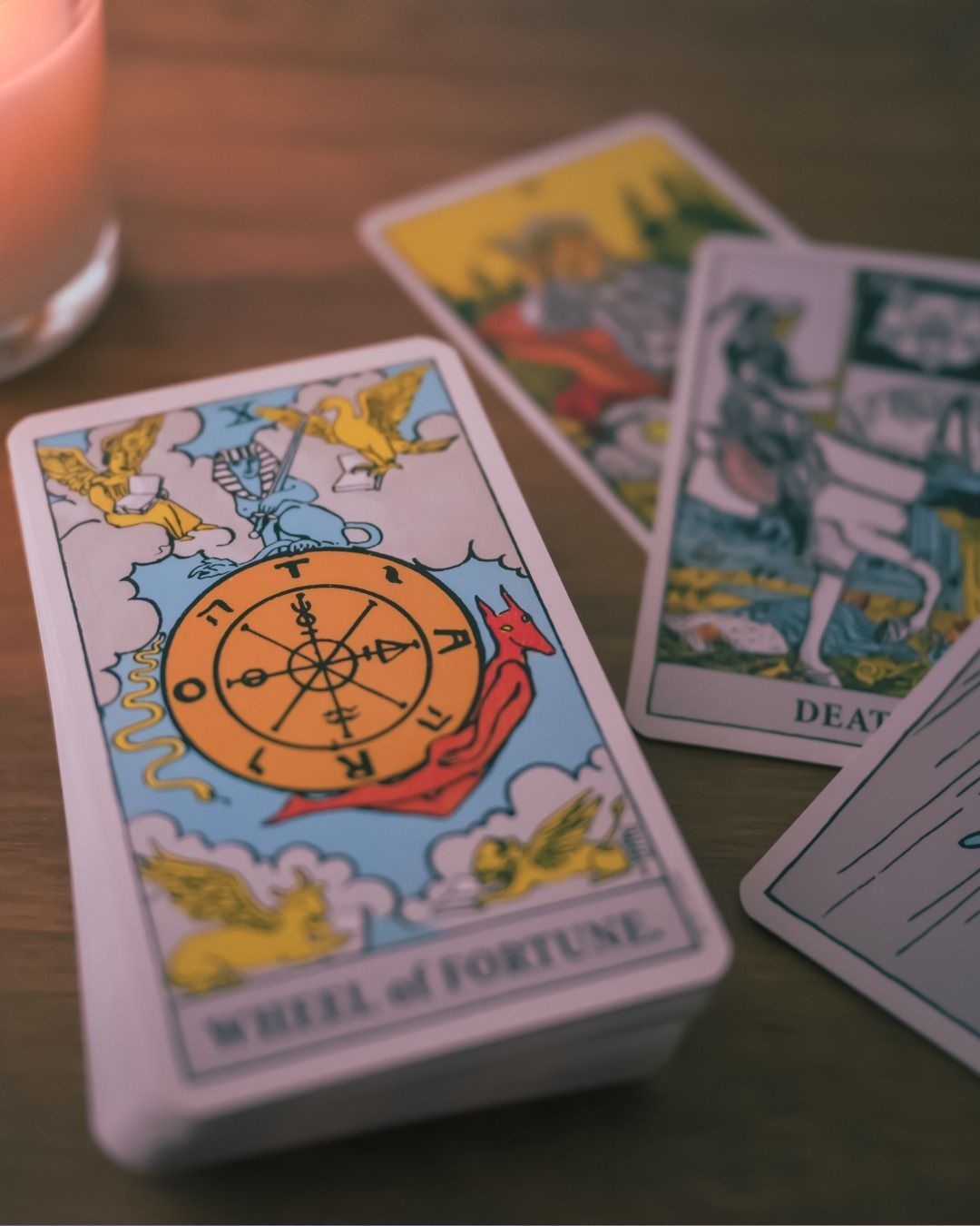 Una pila de cartas del tarot, incluida la rueda de la fortuna.