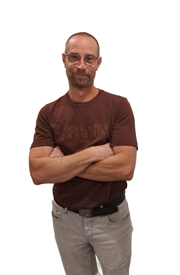 Un homme en t-shirt beige et pantalon clair se détache sur un fond blanc.