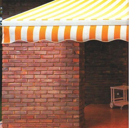Un edificio de ladrillo con un toldo de rayas amarillas y blancas.