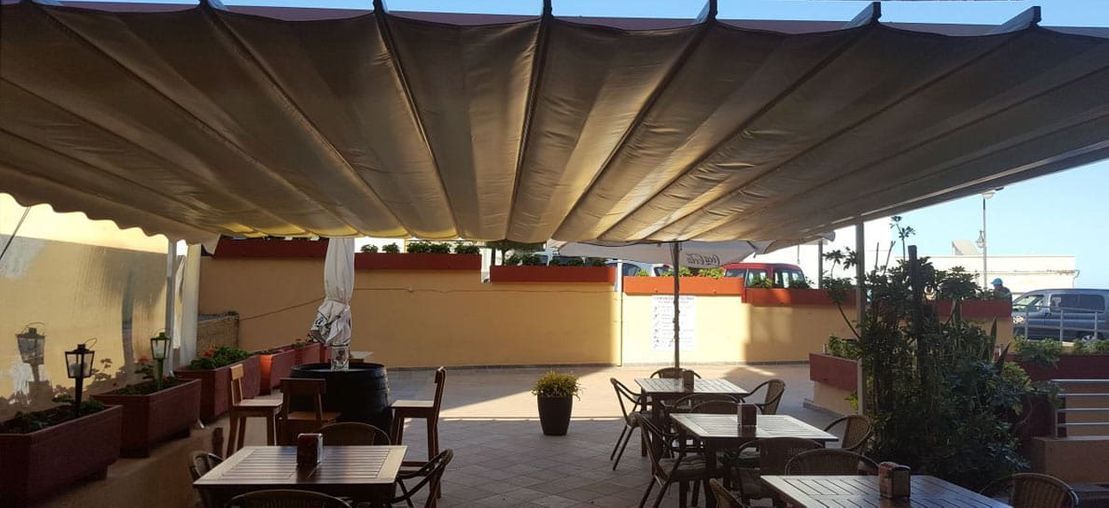 Un restaurante con mesas y sillas bajo un dosel.